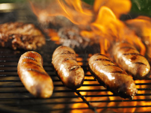 Bratwursts Cooking on a Flaming Grill